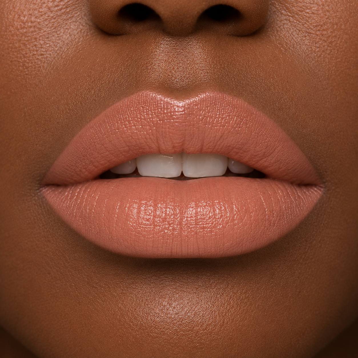 A detailed close up view of full lips on a medium to deep skin tone wearing Hello Biscuit Beauty 9 to 5 creme lipstick, a soft everyday light nude shade with a rich smooth finish