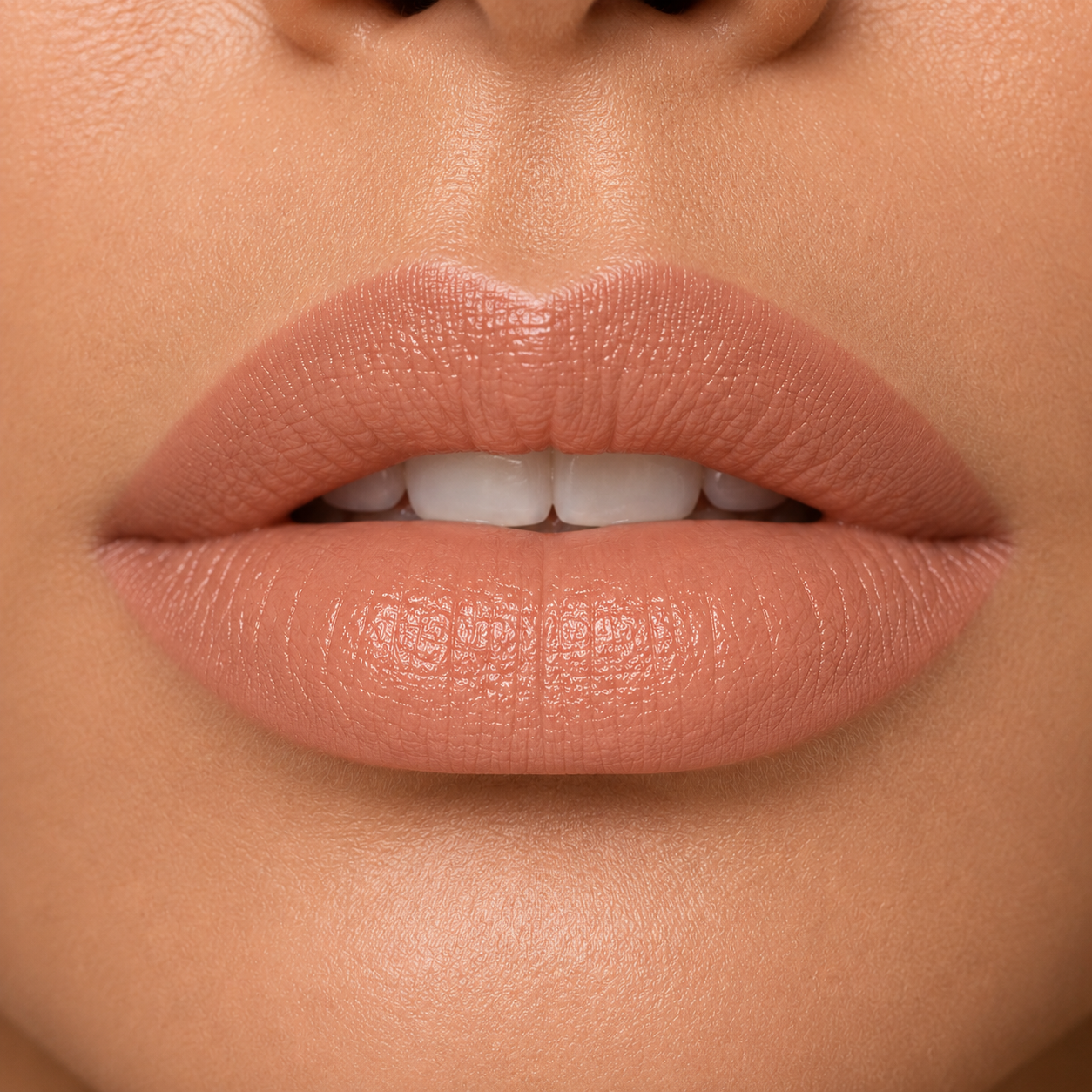 A detailed close up view of full lips on a medium to deep skin tone wearing Hello Biscuit Beauty 9 to 5 creme lipstick, a soft everyday light nude shade with a rich smooth finish