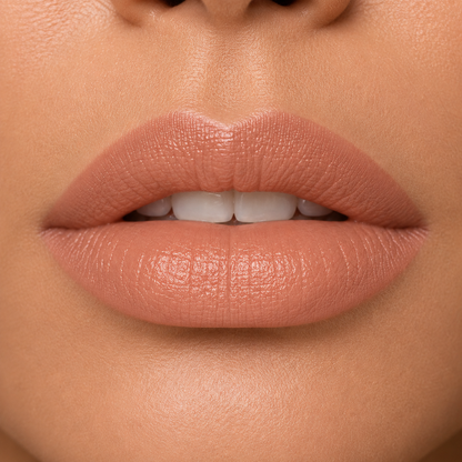 A detailed close up view of full lips on a medium to deep skin tone wearing Hello Biscuit Beauty 9 to 5 creme lipstick, a soft everyday light nude shade with a rich smooth finish