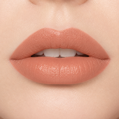 A smiling woman wearing Hello Biscuit Beauty 9 to 5 creme lipstick, showcasing a soft everyday light nude shade with a smooth creamy finish