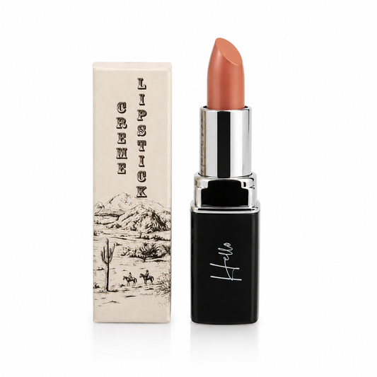 An open tube of Hello Biscuit Beauty 9 to 5 creme lipstick standing next to its custom box featuring a vintage western desert illustration of cowboys and a saguaro cactus on a white background