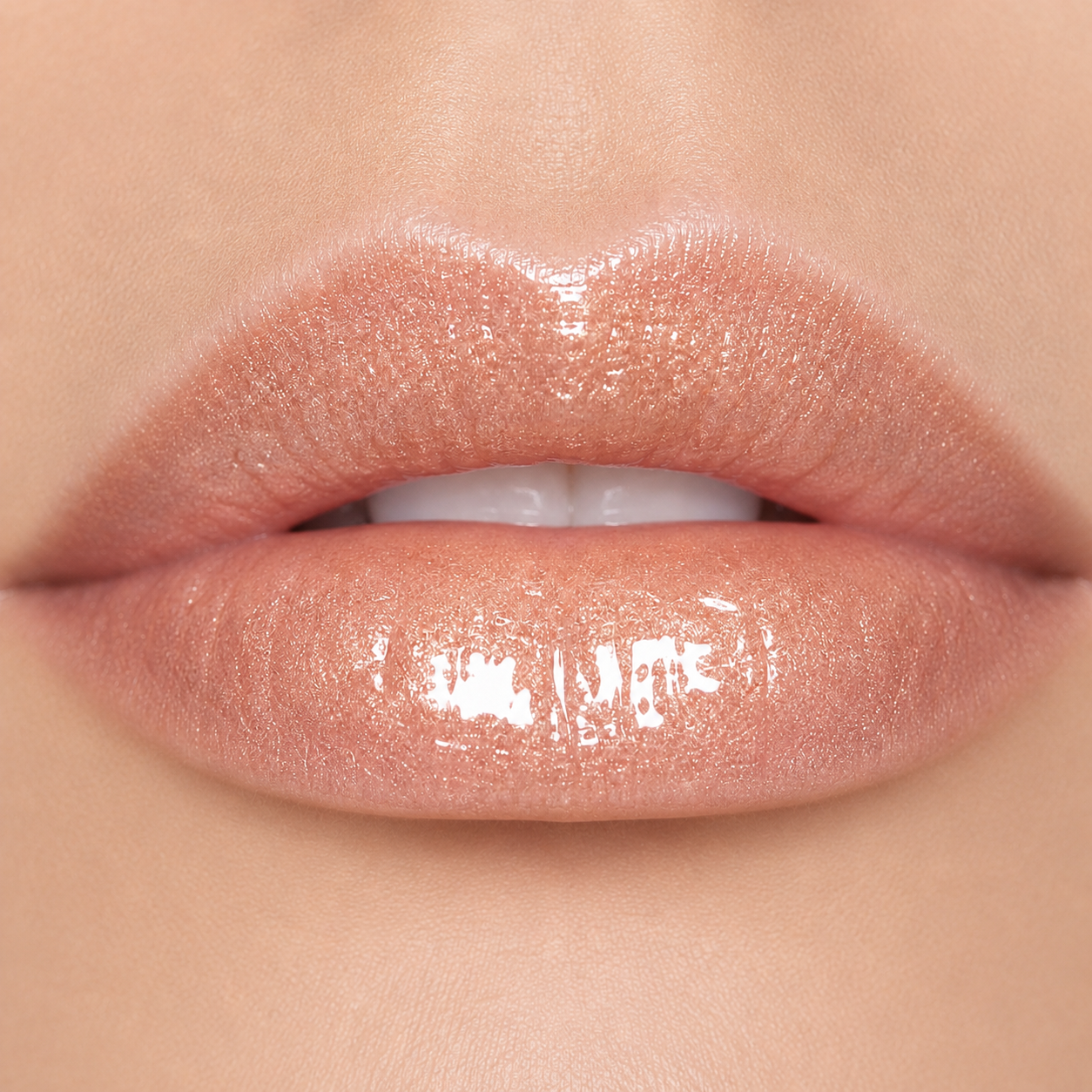 A detailed close up macro view of a model wearing the high shine Hello Biscuit Beauty Palomino Sparkly Mocha Lip Gloss showing a radiant pink shimmer finish