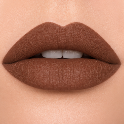 A detailed close up view of full lips wearing Hello Biscuit Beauty Backwoods matte lipstick, a deep muted mocha brown shade with a velvet matte finish