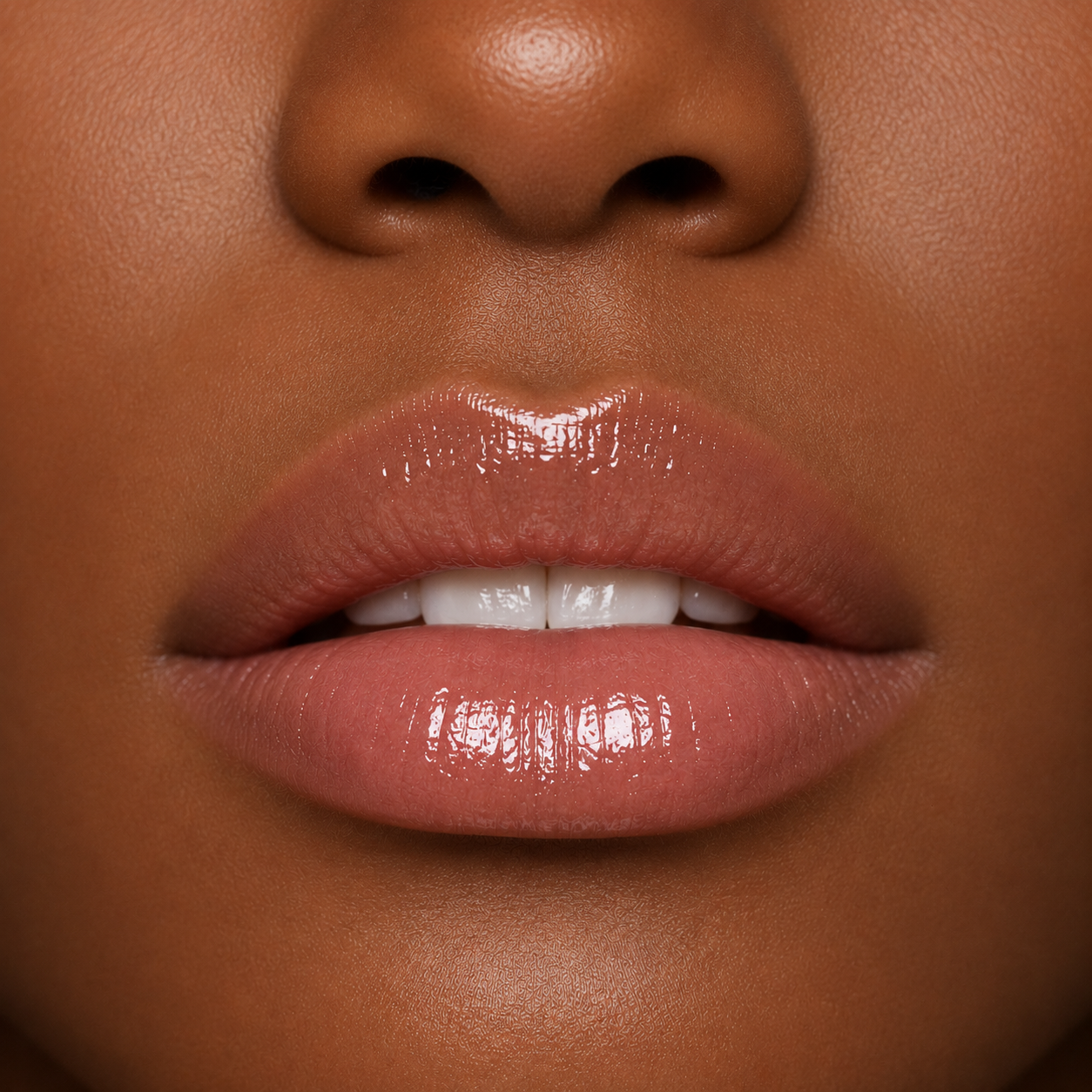 A detailed close up macro view of a model with a deep skin tone wearing the high shine Hello Biscuit Beauty Cowboy Casanova Clear Lip Gloss