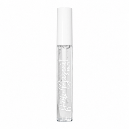 A standing clear tube of Hello Biscuit Beauty Cowboy Casanova Clear Lip Gloss showing the crystal clear formula and white script logo on a white background