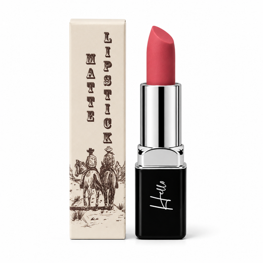 An open tube of Hello Biscuit Beauty Gone Country matte lipstick standing next to its custom white product box featuring a western illustration of cowboys riding horses on a white background