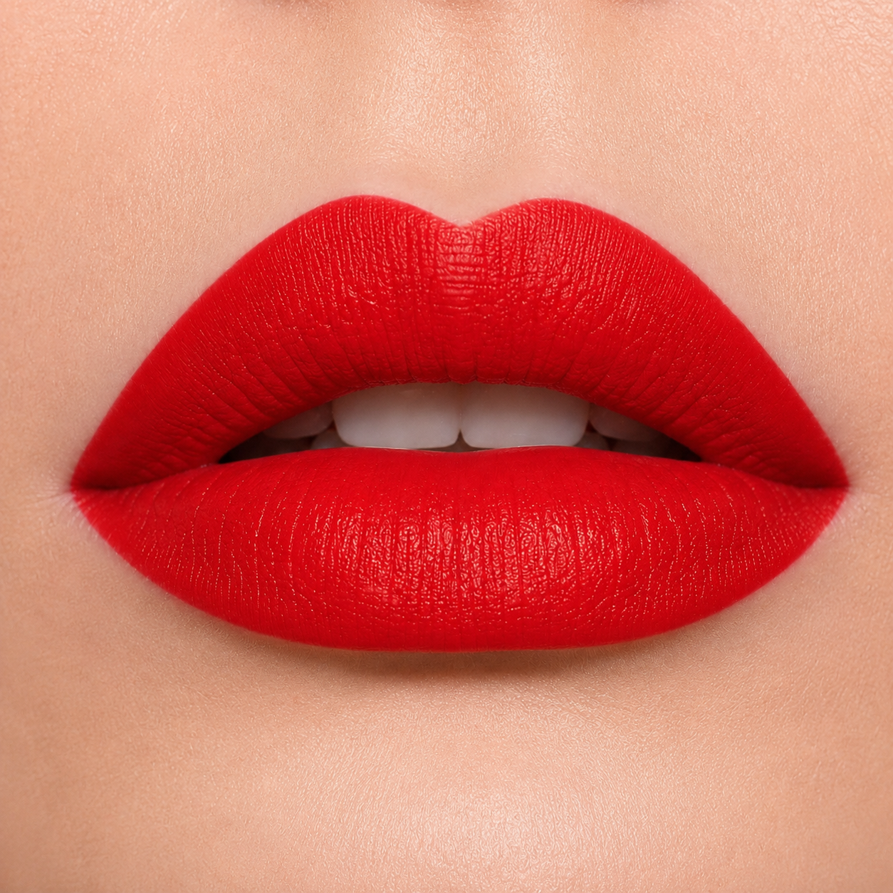A detailed close up macro view of full lips wearing Hello Biscuit Beauty Kiss This creme lipstick, a vibrant bright red statement shade with a smooth creamy finish