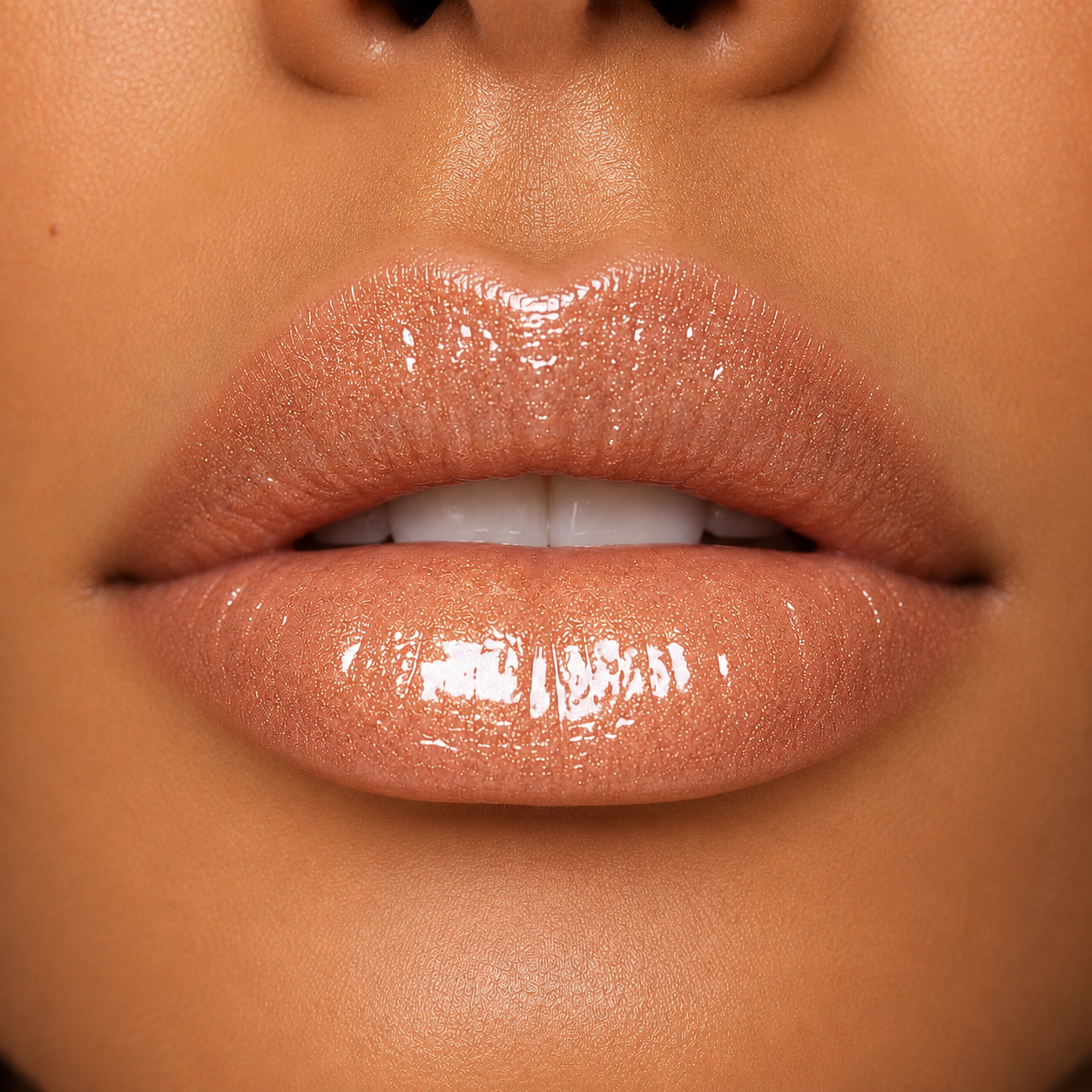 A detailed close up macro view of a model with a warm tan skin tone wearing the ultra shiny Hello Biscuit Beauty Palomino Sparkly Mocha Lip Gloss