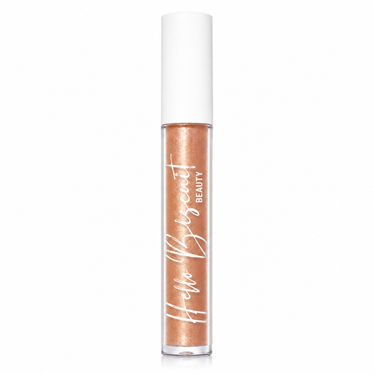 A clear tube of Hello Biscuit Beauty Palomino Sparkly Mocha Lip Gloss showcasing the shimmering mocha liquid formula and white logo on a white background