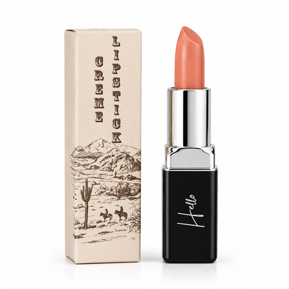 An open tube of Hello Biscuit Beauty Peach Tea creme lipstick standing next to its custom box featuring a vintage western desert illustration of cowboys on a white background