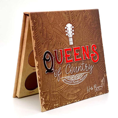 A three quarter standing view of the closed Hello Biscuit Beauty Queens of Country Eye Shadow Palette, showing its brown textured western style cover design with a guitar emblem