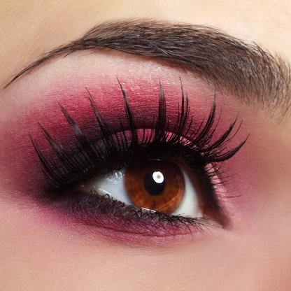A detailed close up macro view of a stunning eye makeup look featuring the bright burnt red and metallic dark pink shades from the Hello Biscuit Beauty Queens of Country Eye Shadow Palette
