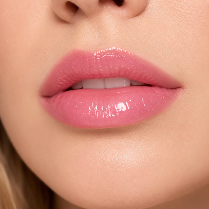 A detailed close up macro view of a model wearing the high shine Hello Biscuit Beauty Strawberry Wine Lip Gloss in a vibrant soft pink shade