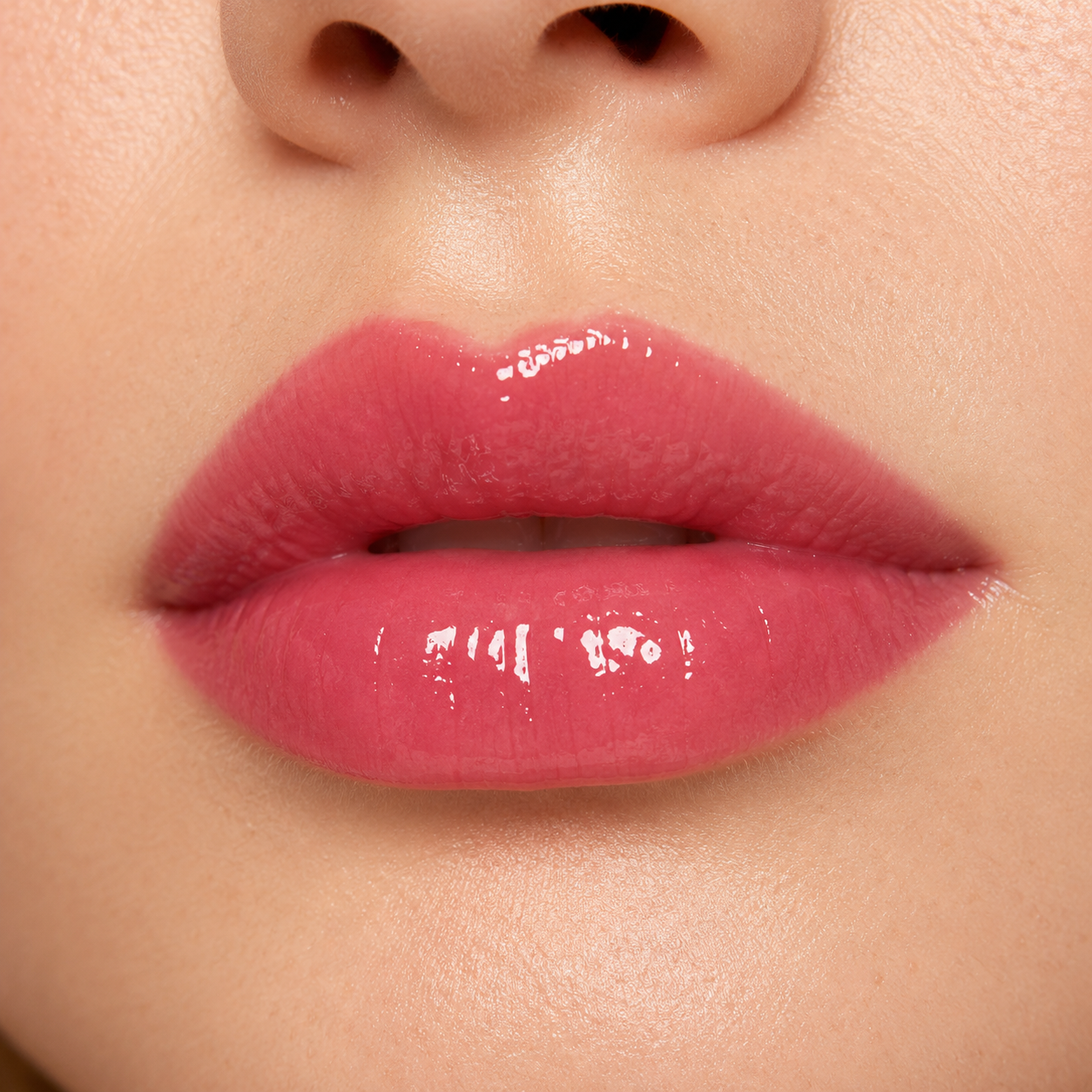 A detailed close up macro view of a model wearing the high shine Hello Biscuit Beauty Watermelon Crawl Lip Gloss in a vibrant dark pink shade